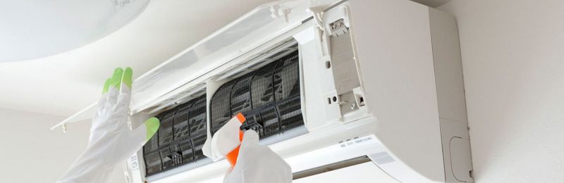 HVAC technician repairing an air conditioner unit in Lemon Grove CA